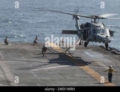 U.S. Marines conduct fast-rope drills aboard amphibious assault ship USS America. Stock Photo