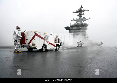 Sailors aboard USS Abraham Lincoln standby for emergency response on the flight deck. Stock Photo