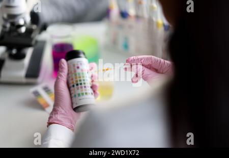 Clever scientist hold litmus test paper for soil analysis, papers show acidity Stock Photo