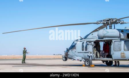 Airman signals a MH-60S Sea Hawk helicopter prior to flight operations. Stock Photo