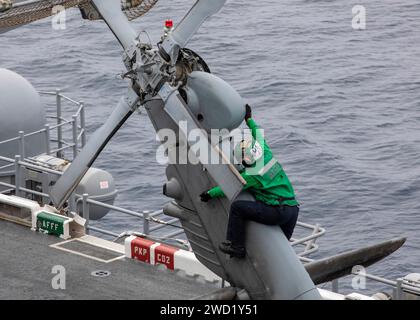 Aviation Machinist's Mate performs maintenance an MH-60S Sea Hawk helicopter. Stock Photo