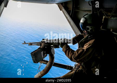 U.S. Marine Corps MV-22B Osprey crew chief fires an M240B machine gun. Stock Photo