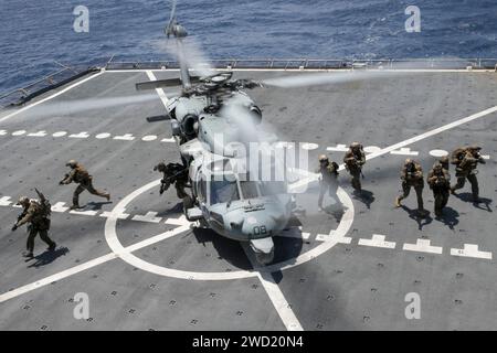 U.S. Marines exit an SH-60 Sea Hawk helicopter aboard USNS Richard E. Byrd. Stock Photo