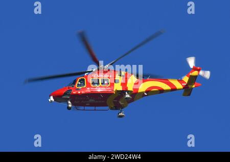 An Essex & Herts Air Ambulance flying over the Thames before preparing to land in Tilbury. Stock Photo