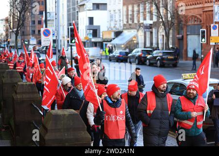 Public sector workers from Northern Ireland Public Service Alliance (NIPSA) walk the picket line from Northern Ireland Office (NIO) to Belfast City Hall, as an estimated 150,000 workers take part in walkouts over pay across Northern Ireland. The strike is set to have a major impact with schools closed, hospitals offering only Christmas Day-level services, public transport cancelled as well as limited gritting of the roads in zero-degree temperatures. Picture date: Thursday January 18, 2024. Stock Photo