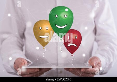 Customer satisfaction concept above a tablet held by a man in background Stock Photo