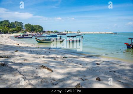 Fishing boats on the sea and beach of George Town city in the distance on the Strait of Malacca in Penang, Malaysia.  Stock Photo