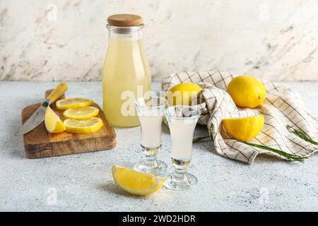 Bottle and shots of tasty Limoncello on white background Stock Photo