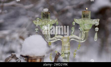 A glass candle holder. A silver coffeepot covered with snow. Stock Photo