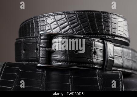 Part of a black crocodile leather belt. Expensive leather goods. Stock Photo