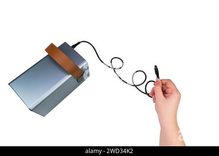 USB cable in hand, connected to a large power supply (charging station), isolated on a white background. Mobile power supply Stock Photo