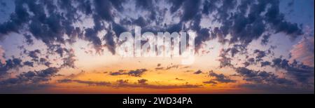 Dramatic sunset sky with fluffy clouds. Dramatic natural cloudscape at dusk. Stock Photo