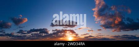 Dramatic sunset sky with fluffy clouds. Dramatic natural cloudscape at dusk. Stock Photo