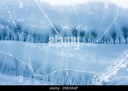 Texture of frozen lake with cracks covered with snow. Top view. Stock Photo