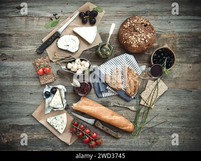 French food on a wooden background. Different types of cheese, wine and other ingredients on a wooden table Stock Photo