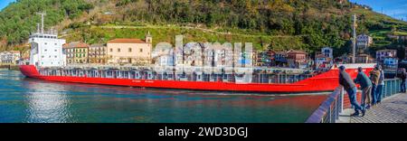 An oil tanker crossing in front of the fishing village of Pasajes de San Juan. Gipuzkoa, Basque country, Spain. Stock Photo