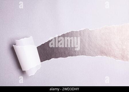 Torn paper with opening showing black background Stock Photo