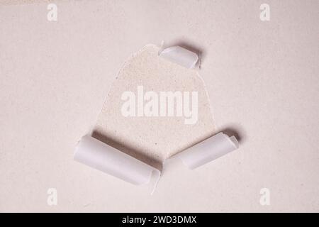 Torn paper with opening showing cardboard paper background. Stock Photo