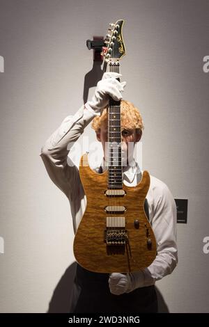 LONDON, UNITED KINGDOM - JANUARY 18, 2023: A staff member holds Pensa-Suhr, New York, 1988, a solid-body electric guitar, MK-1, estimate: £6,000-8,000 which was used at the Nelson Mandela 70th Birthday Tribute concert on 11 June 1988 at Wembley Stadium during a photocall at Christie's auction house showcasing the highlights from the personal collection of Mark Knopfler, frontman of the iconic British band, Dire Straits, in London, United Kingdom on January 18, 2023. The guitars will be offered at an auction on January 31 and 25% of the total hammer price will be donated to The British Red Cros Stock Photo