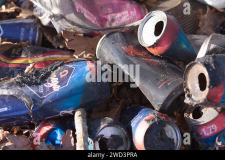 Discarded and empty alcohol cans lay in a heap on the ground. Stock Photo