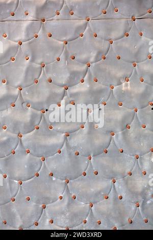 Grunge metal surface texture background, distressed fragment close up with welded patches and nails Stock Photo