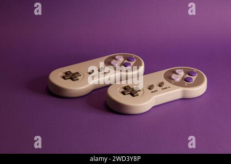 Nintendo type video game contollers on a mouve background, studio photography Stock Photo