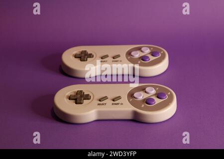 Nintendo type video game contollers on a mouve background, studio photography Stock Photo