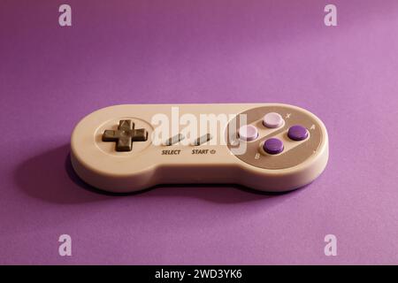 Nintendo type video game contollers on a mouve background, studio photography Stock Photo