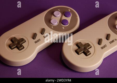 Nintendo type video game contollers on a mouve background, studio photography Stock Photo
