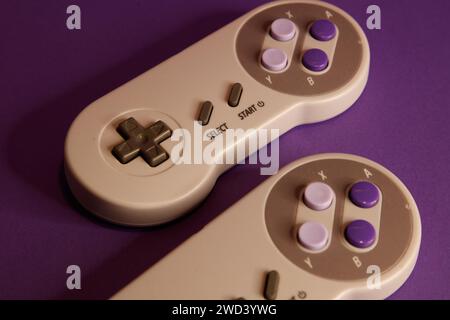 Nintendo type video game contollers on a mouve background, studio photography Stock Photo