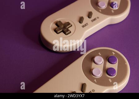 Nintendo type video game contollers on a mouve background, studio photography Stock Photo