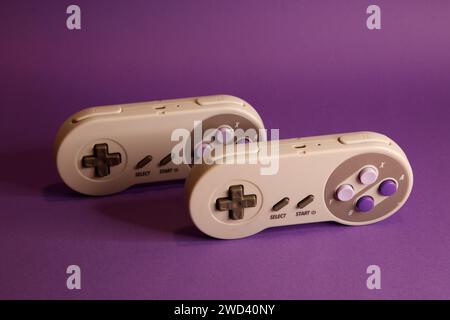 Nintendo type video game contollers on a mouve background, studio photography Stock Photo