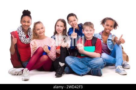 group of schoolmates sitting on the floor isolated on white background Stock Photo
