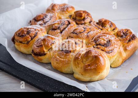 cooked baked sweet bun rolls with chocolate filling, on a wooden table. Stock Photo