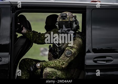 Special forces soldier in black Mercedes van. Tactical uniform worn by  Czech border force. Man in gas mask Stock Photo