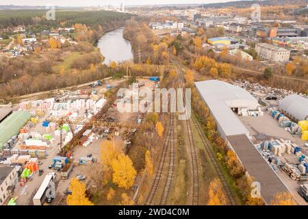 Drone photography of railway going to industrial park in a city during autumn sunny day Stock Photo