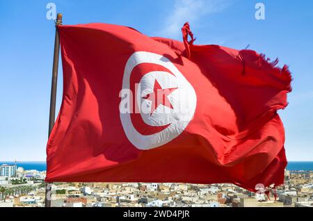 Waving tunisian flag on the background of the medieval medina in Sousse, Tunisia. Stock Photo
