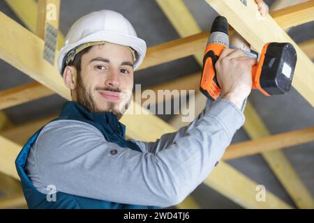 mature carpenter drilling wood Stock Photo