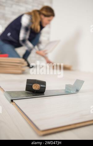construction worker handywoman installing new wood floor at house Stock Photo