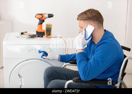 young plumber repairing washing machine Stock Photo