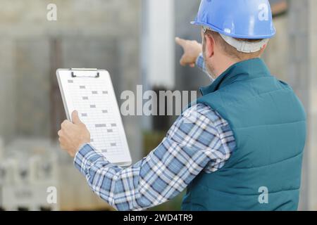 warehouse worker pointing with finger while standing Stock Photo