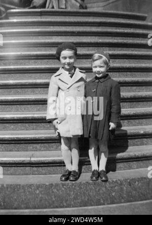 An antique photo shows two little girls in demi-season coats standing on the stairs. Germany. Date unknown, circa 1930s Stock Photo