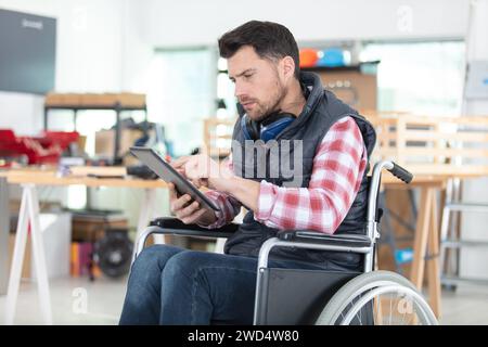 disabled worker in wheelchair in a carpenters workshop Stock Photo