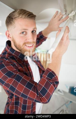 man replacing the light bulb on the ceiling Stock Photo - Alamy