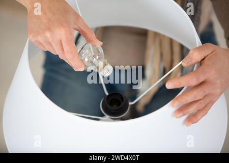 hand turns the switch on a lamp Stock Photo