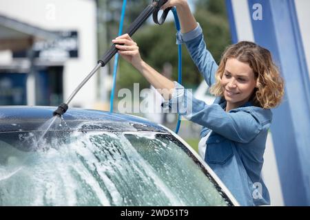 woman cleaning car using high pressure water Stock Photo