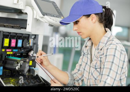 young female technician fixing a printer Stock Photo