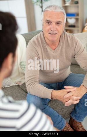 mature men on sofa chatting Stock Photo