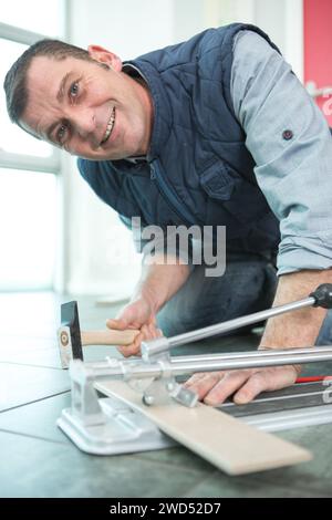 portrait of happy man cutting tiles Stock Photo