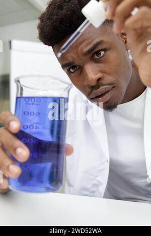 young man scientist using auto-pipette with flask in laboratory Stock Photo
